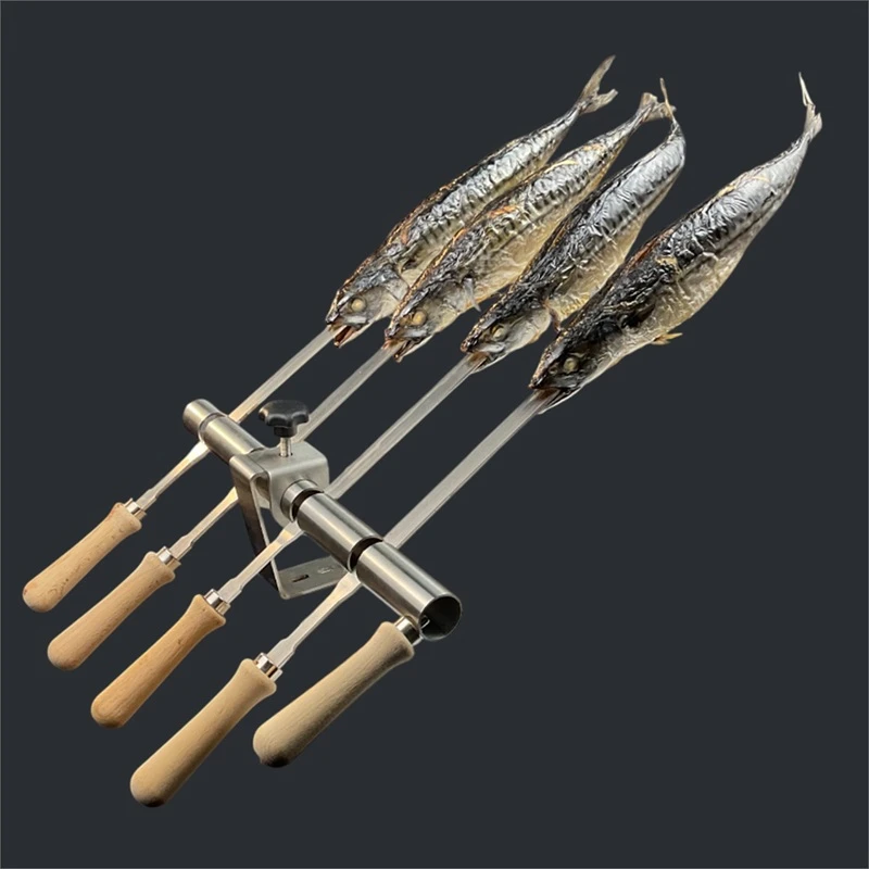 Grillspieße mit mehreren ganzen Fischen, befestigt an einer Edelstahlhalterung mit Holzgriffen.